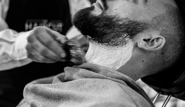 A barber student cleaning and prepping equipment.