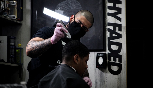 Barber students cutting hair for clients.